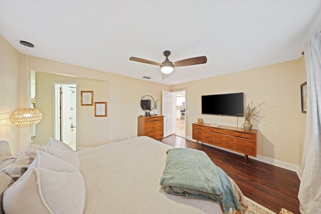 bedroom featuring ensuite bath, ceiling fan, dark hardwood / wood-style flooring, and a textured ceiling