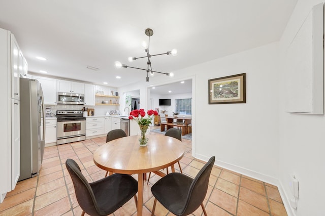 dining area featuring light tile patterned flooring, sink, and an inviting chandelier