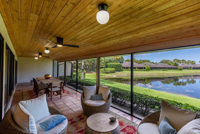 sunroom featuring ceiling fan, wood ceiling, vaulted ceiling, and a water view