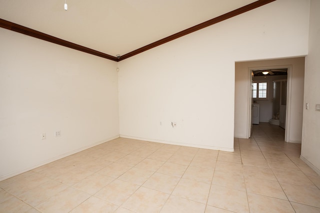 empty room featuring washer / dryer, light tile patterned floors, and ornamental molding