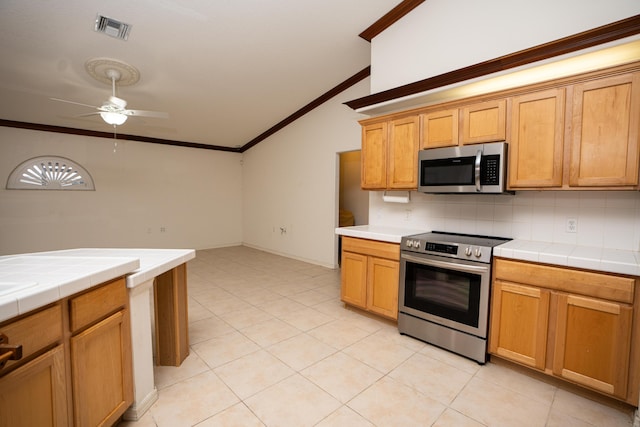 kitchen with decorative backsplash, tile counters, ceiling fan, and stainless steel appliances