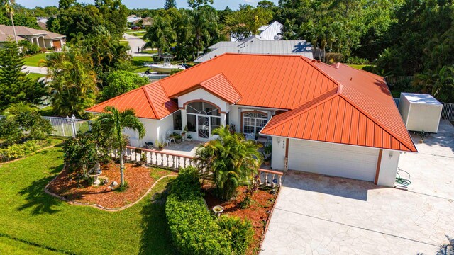 411 SE Duff Ct, Port Saint Lucie, FL 34984 - view of front facade featuring stucco siding, a metal roof, a standing seam roof, and concrete driveway