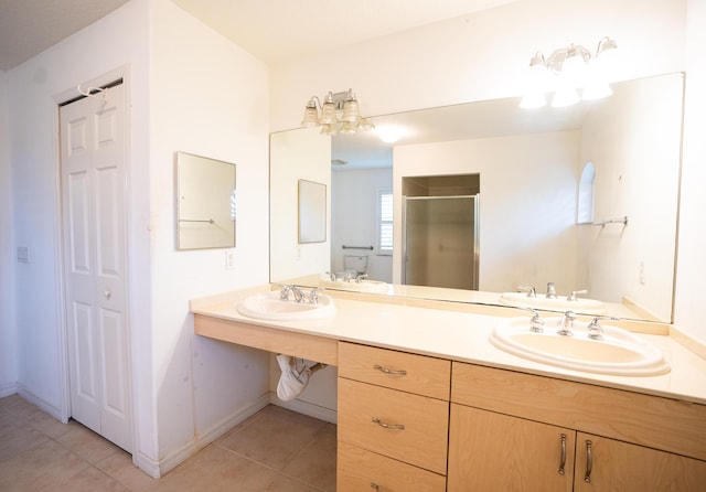 bathroom featuring tile patterned floors, a shower with door, and vanity