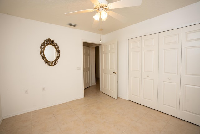 unfurnished bedroom with ceiling fan and a closet