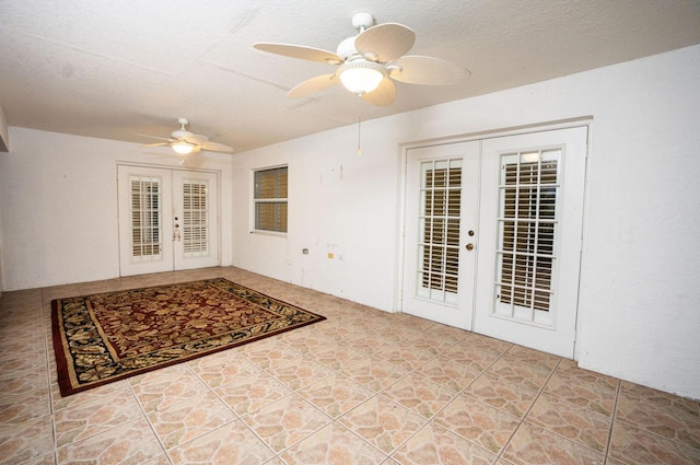 unfurnished room featuring french doors, a textured ceiling, and ceiling fan