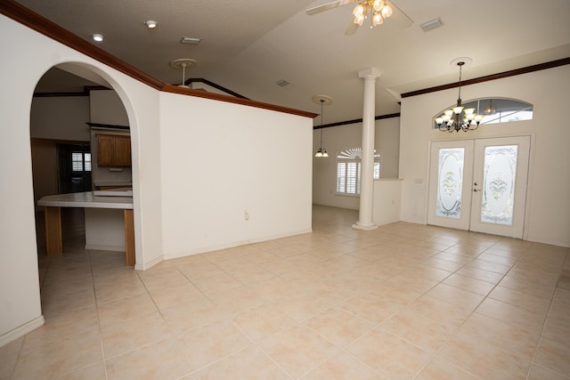 tiled entrance foyer with ceiling fan with notable chandelier, a healthy amount of sunlight, lofted ceiling, and french doors