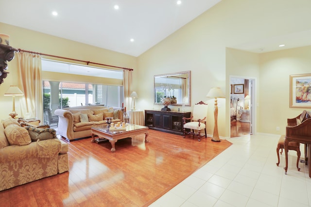 living room featuring high vaulted ceiling and light hardwood / wood-style flooring