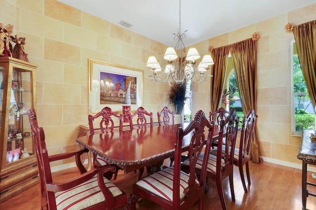 dining space featuring tile walls, wood-type flooring, and a wealth of natural light