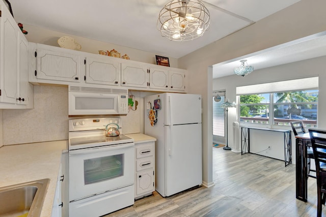 kitchen with light wood-type flooring, a chandelier, white cabinets, white appliances, and decorative light fixtures