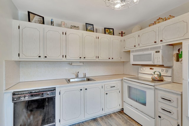 kitchen featuring light wood-type flooring, white appliances, sink, and white cabinets