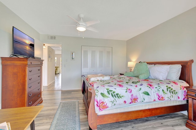 bedroom with light hardwood / wood-style floors, ceiling fan, and a closet