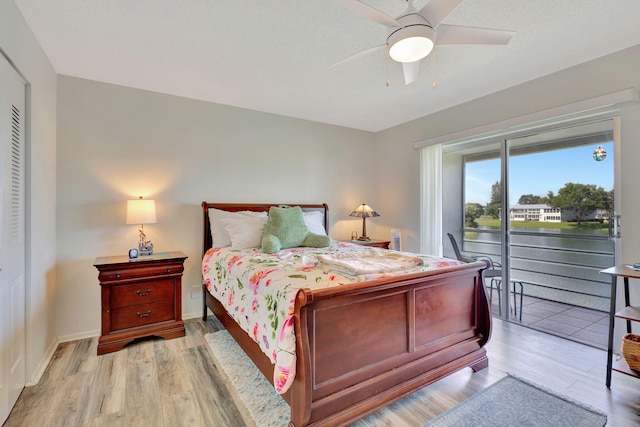 bedroom featuring access to outside, light hardwood / wood-style floors, ceiling fan, and a closet