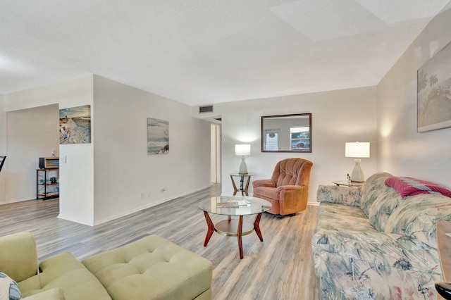 living room featuring wood-type flooring and a textured ceiling