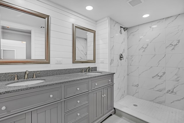 bathroom featuring a tile shower and vanity