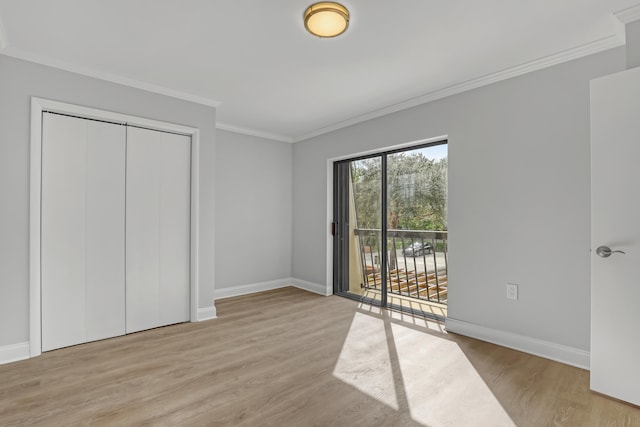 unfurnished bedroom featuring light wood-type flooring, access to outside, a closet, and ornamental molding