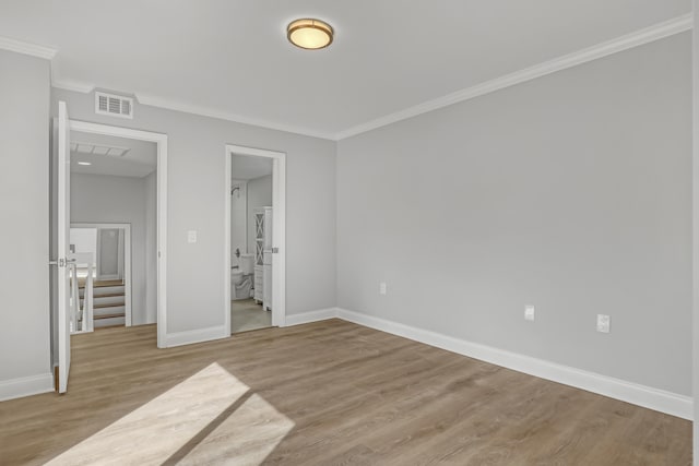 unfurnished bedroom with light hardwood / wood-style floors, ornamental molding, and ensuite bath