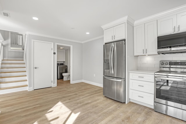 kitchen featuring light hardwood / wood-style flooring, tasteful backsplash, white cabinetry, stainless steel appliances, and washer / clothes dryer