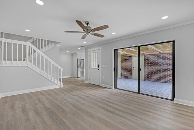 unfurnished living room featuring crown molding, light hardwood / wood-style flooring, ceiling fan, and brick wall