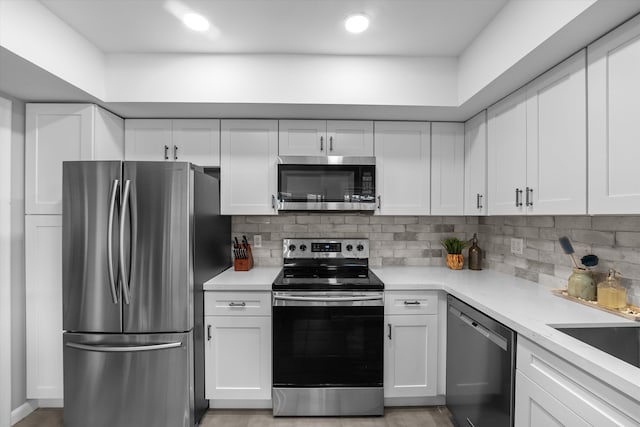 kitchen with tasteful backsplash, appliances with stainless steel finishes, and white cabinets