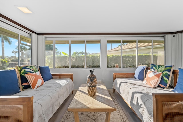 bedroom with multiple windows, hardwood / wood-style flooring, and ornamental molding