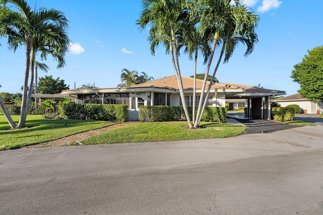 single story home featuring a carport and a front lawn