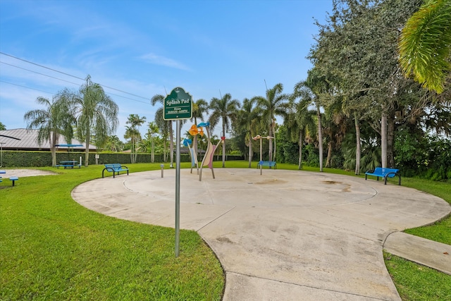 view of community featuring basketball hoop and a lawn