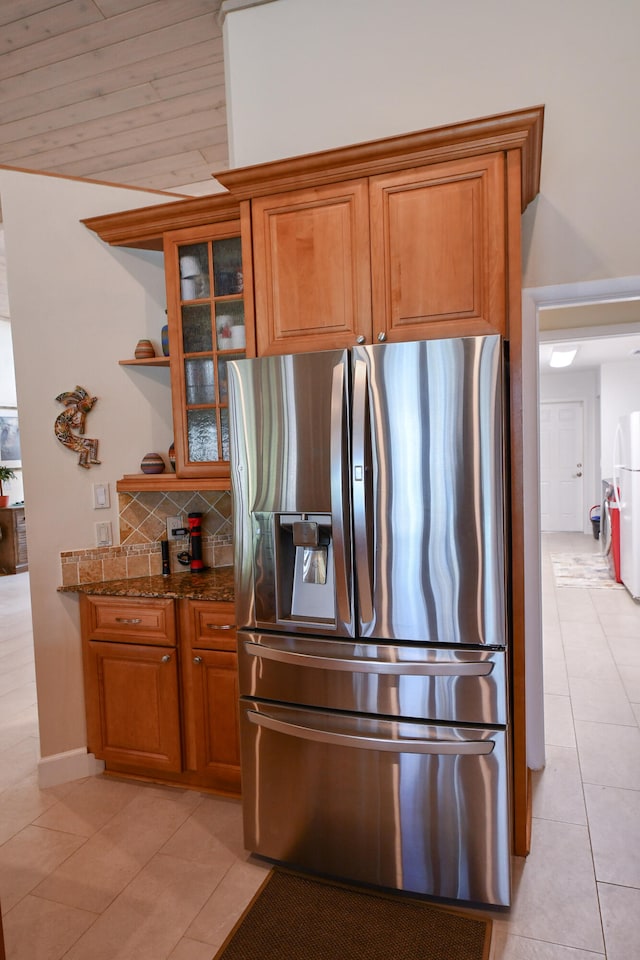 kitchen with wood ceiling, light tile patterned floors, stainless steel refrigerator with ice dispenser, light stone countertops, and decorative backsplash