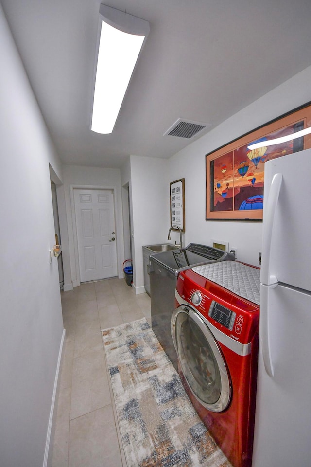 laundry room featuring light tile patterned flooring, hookup for a washing machine, and sink