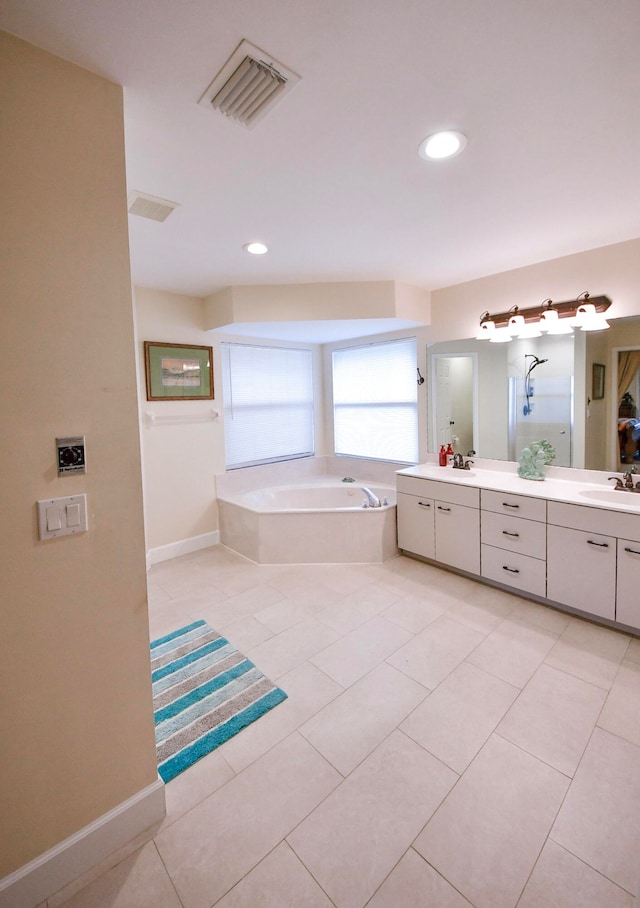 bathroom featuring tile patterned flooring, a tub to relax in, and vanity