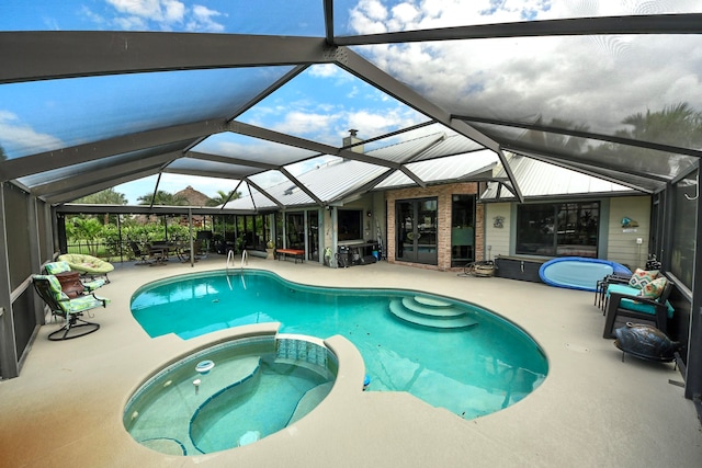 view of swimming pool featuring a lanai, an in ground hot tub, and a patio