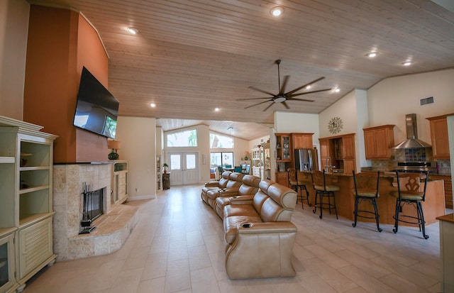 living room with a high end fireplace, wood ceiling, high vaulted ceiling, and ceiling fan