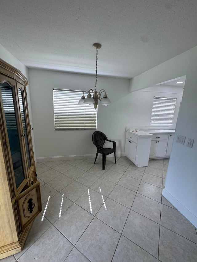 unfurnished dining area with a notable chandelier, a healthy amount of sunlight, and light tile patterned flooring