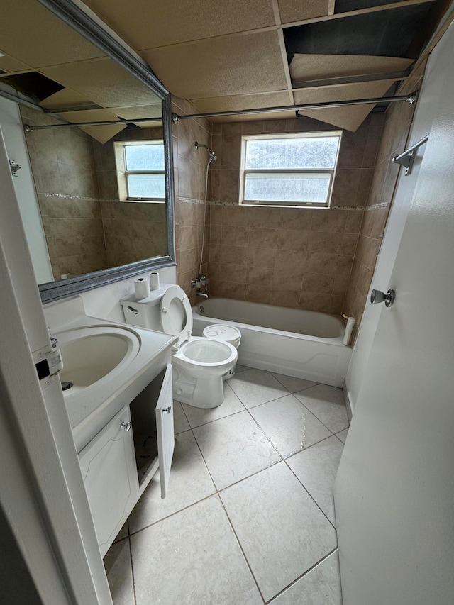 full bathroom featuring vanity, tile patterned floors, toilet, and tiled shower / bath