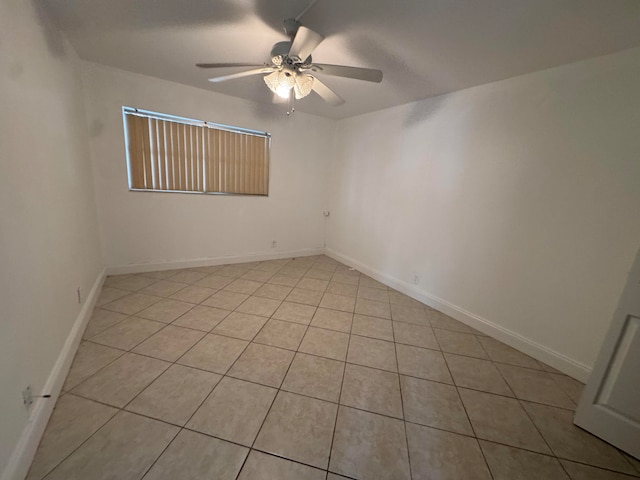 empty room with ceiling fan and light tile patterned floors