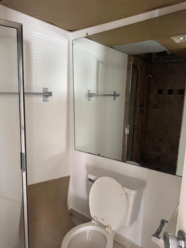 bathroom featuring toilet and a tile shower