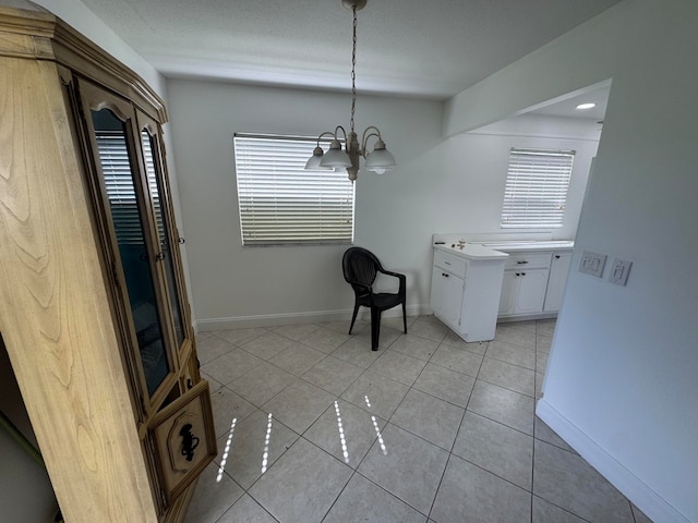 unfurnished dining area with light tile patterned flooring and an inviting chandelier