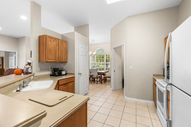 kitchen with white appliances, sink, light tile patterned flooring, an inviting chandelier, and decorative light fixtures