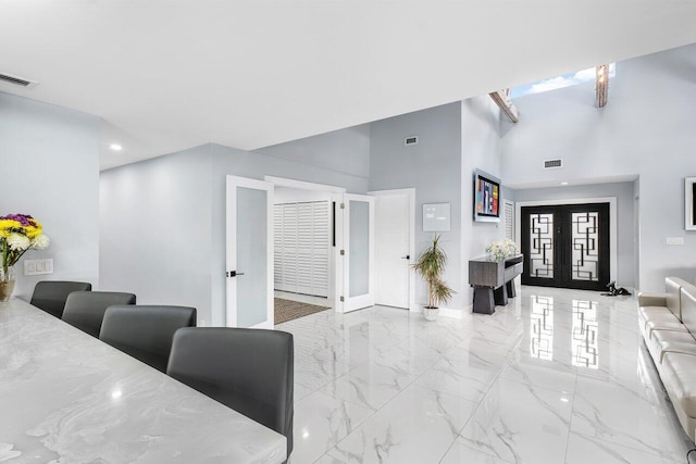 living room featuring french doors and a high ceiling