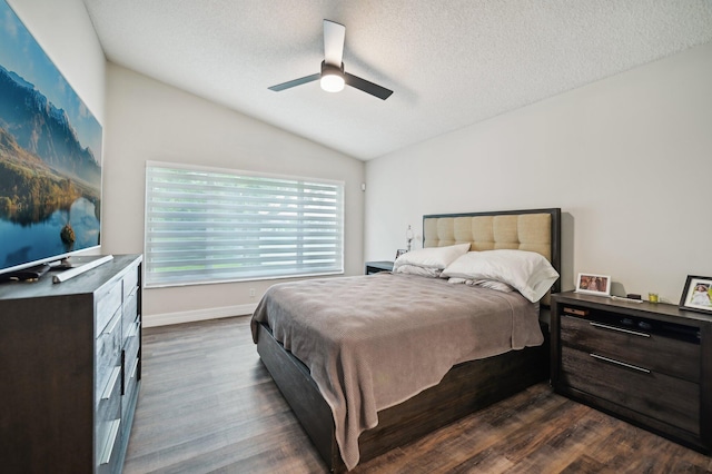 bedroom with a textured ceiling, lofted ceiling, ceiling fan, and dark wood-type flooring