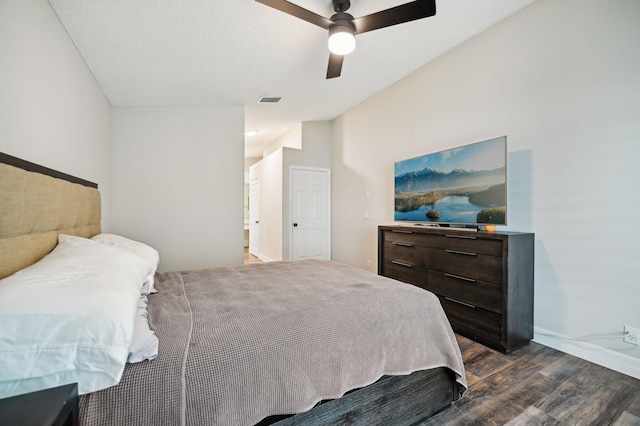 bedroom featuring ceiling fan, dark hardwood / wood-style flooring, lofted ceiling, and a textured ceiling