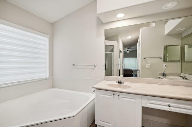 bathroom featuring plus walk in shower and vanity