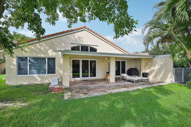 rear view of house featuring a yard and a patio