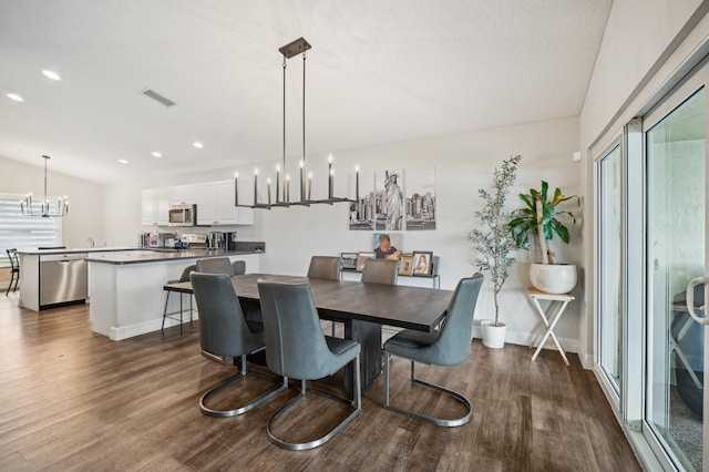 dining room with dark hardwood / wood-style floors and a notable chandelier