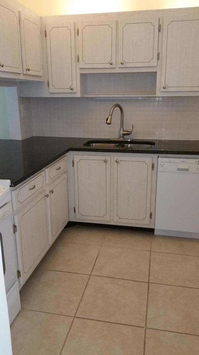 kitchen featuring light tile patterned floors, sink, white dishwasher, and tasteful backsplash