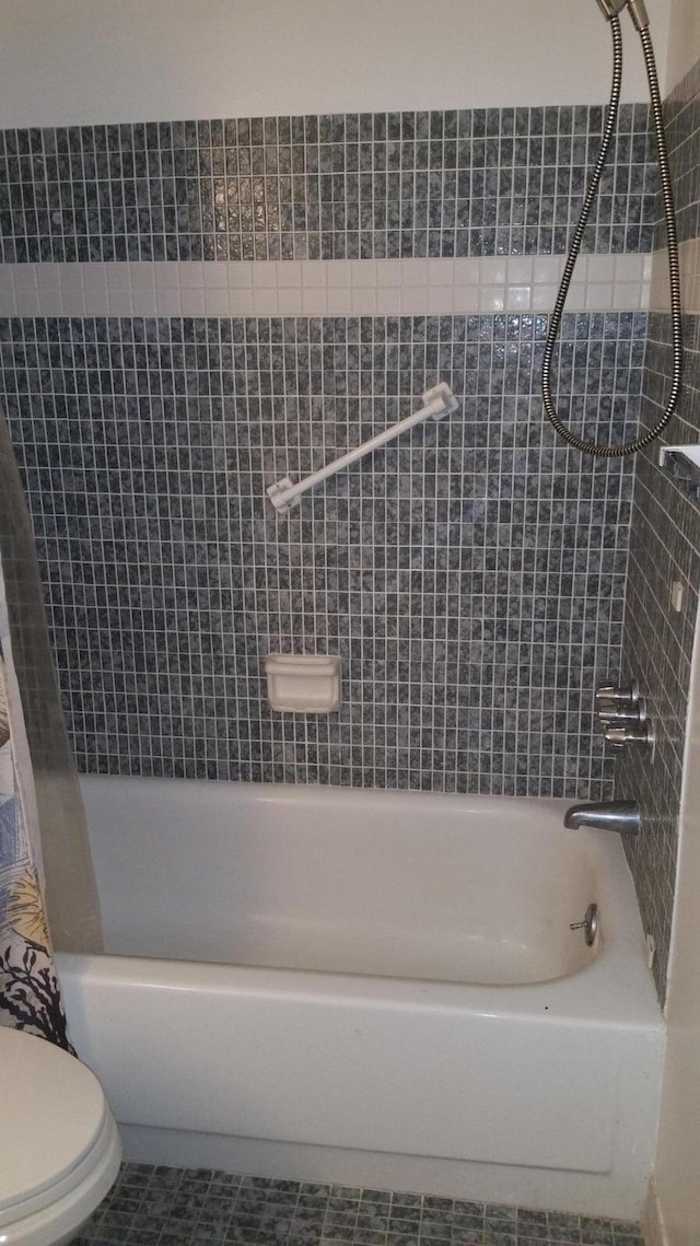 bathroom with shower / bathtub combination with curtain, tile patterned floors, and toilet