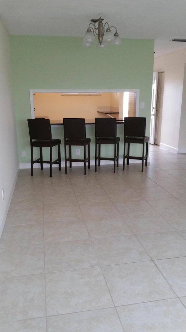 dining area with light tile patterned flooring and a chandelier