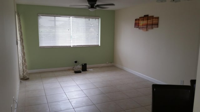 tiled spare room featuring ceiling fan