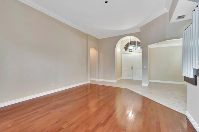 foyer entrance with crown molding and light tile patterned floors