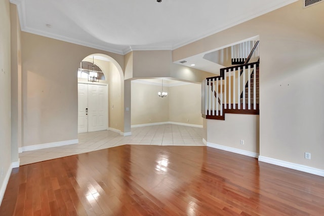 foyer entrance featuring a notable chandelier, crown molding, and light tile patterned floors