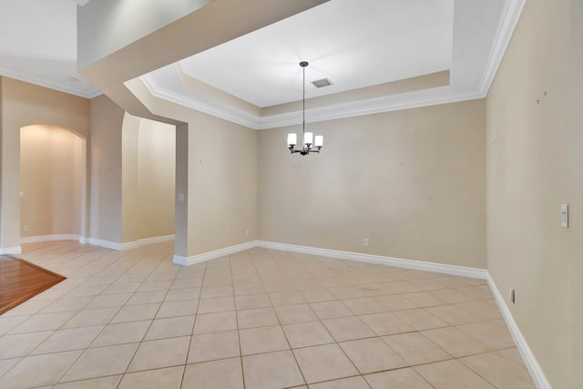 empty room featuring ornamental molding, a raised ceiling, a chandelier, and light tile patterned flooring